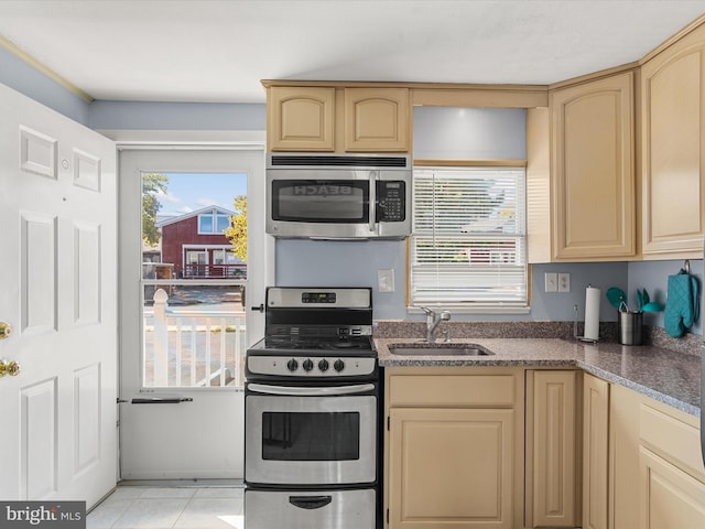 kitchen featuring light tile patterned flooring, stainless steel appliances, light brown cabinetry, and sink