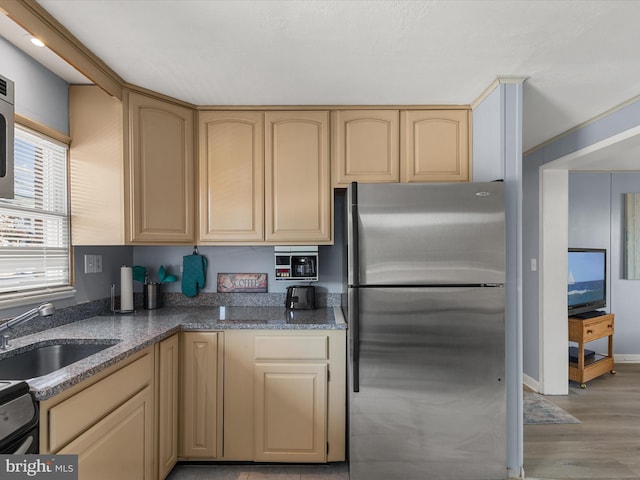 kitchen featuring light hardwood / wood-style flooring, stainless steel refrigerator, sink, and light brown cabinets