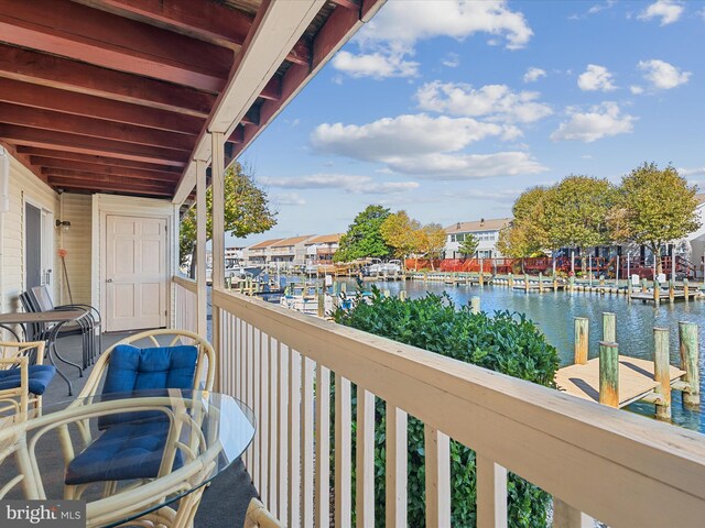 balcony with a water view and a dock