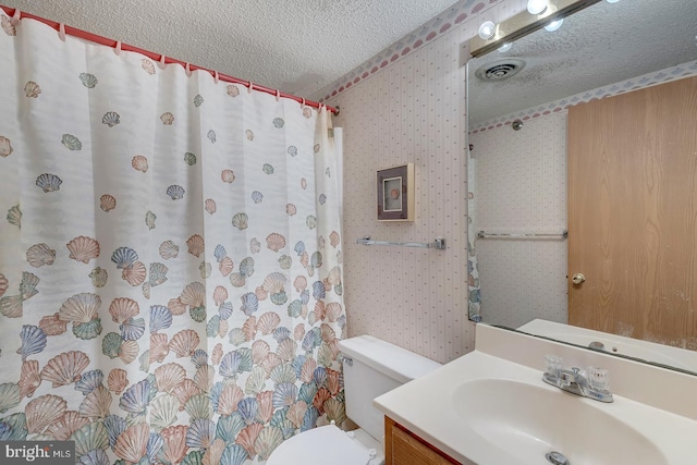 bathroom featuring walk in shower, vanity, a textured ceiling, and toilet