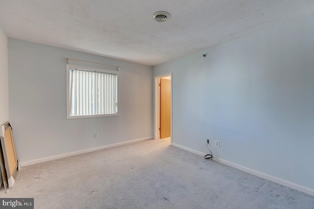 carpeted spare room with a textured ceiling