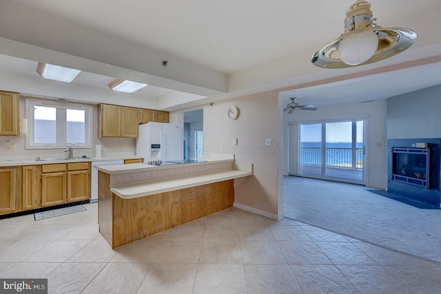 kitchen featuring white appliances, light colored carpet, sink, and plenty of natural light