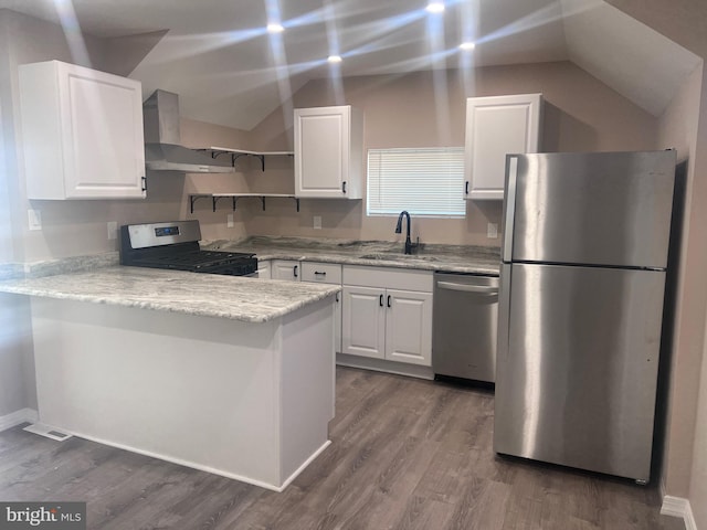 kitchen with lofted ceiling, sink, stainless steel appliances, and white cabinets