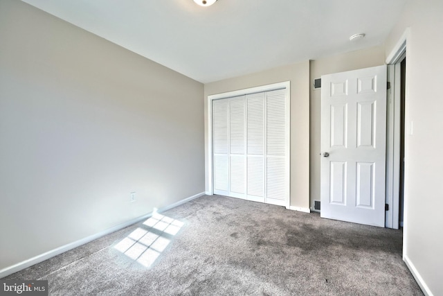 unfurnished bedroom featuring a closet and dark carpet