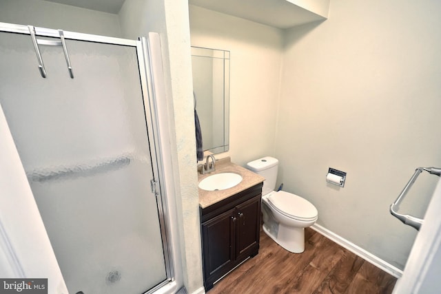 bathroom featuring toilet, walk in shower, vanity, and wood-type flooring