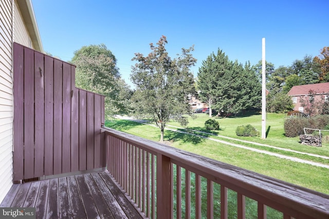 wooden terrace featuring a lawn