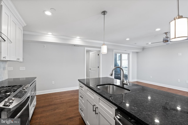 kitchen featuring dark stone counters, white cabinets, decorative light fixtures, and sink