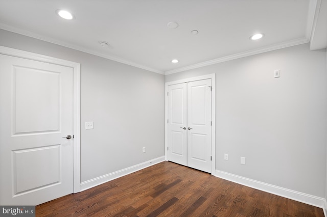 unfurnished bedroom featuring dark wood-type flooring, a closet, and ornamental molding