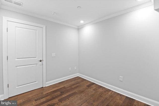 empty room with ornamental molding and dark hardwood / wood-style flooring