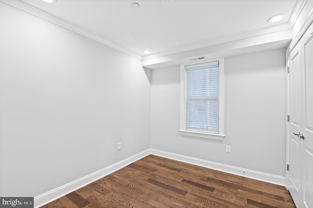 spare room with ornamental molding and dark hardwood / wood-style floors