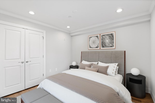 bedroom with ornamental molding, hardwood / wood-style floors, and a closet