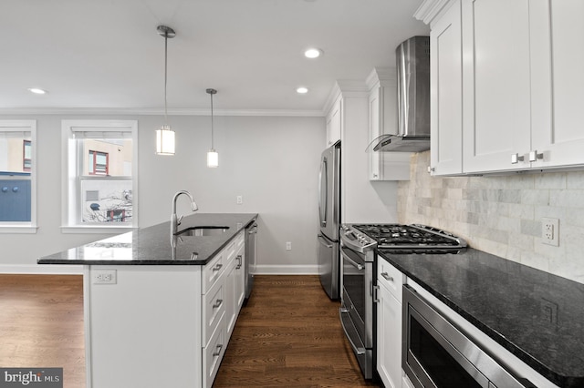 kitchen featuring sink, wall chimney exhaust hood, white cabinetry, stainless steel appliances, and dark stone countertops