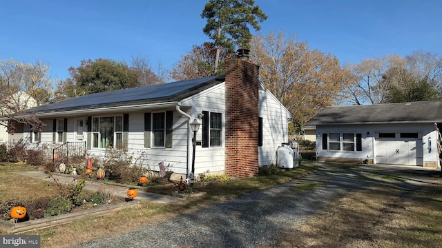 view of property exterior with an outbuilding, solar panels, and a garage