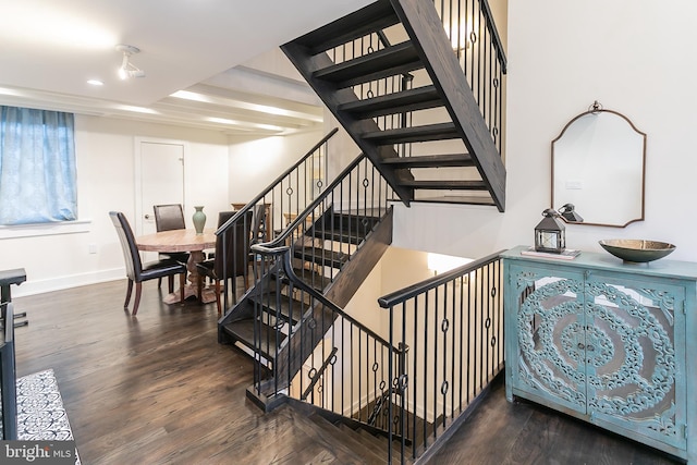 stairs featuring beam ceiling and wood-type flooring