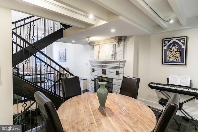 dining area featuring beam ceiling and a fireplace