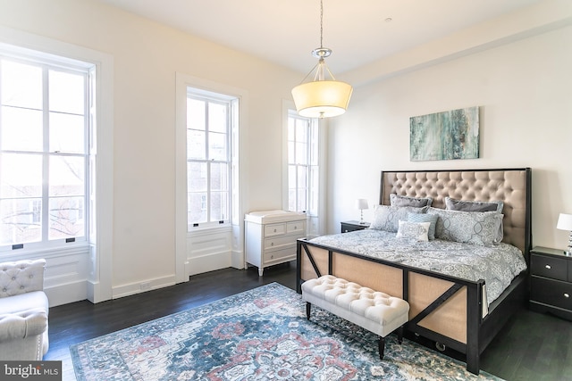 bedroom with dark wood-type flooring and multiple windows