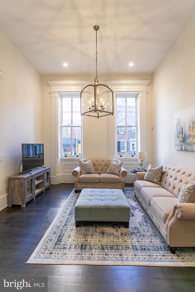 living room with dark hardwood / wood-style floors, a chandelier, and a wealth of natural light