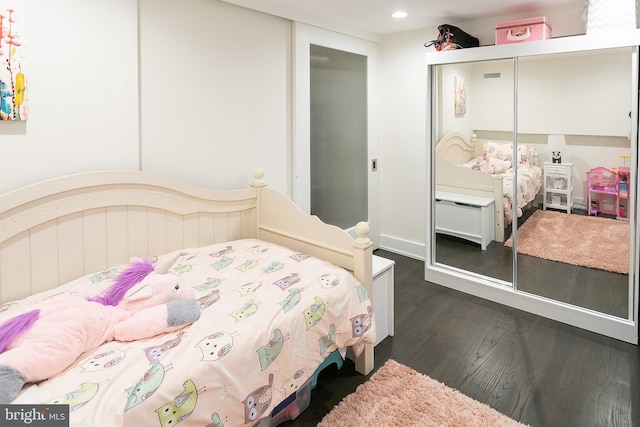 bedroom with a closet and dark hardwood / wood-style flooring