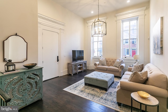 living room with a chandelier, a wealth of natural light, and dark hardwood / wood-style flooring