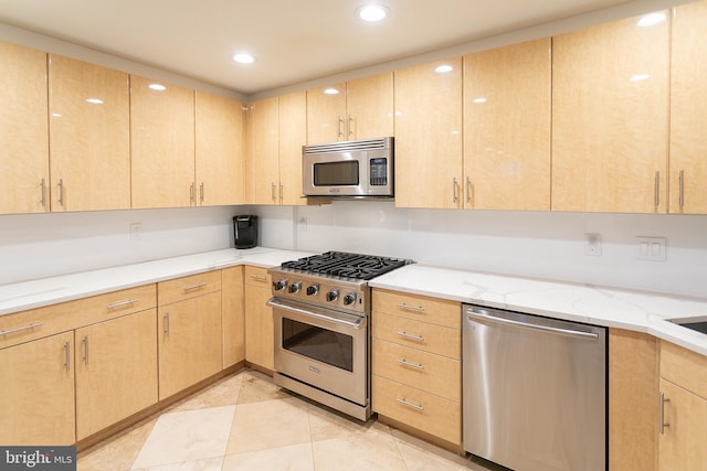 kitchen featuring light brown cabinetry, appliances with stainless steel finishes, light stone countertops, and light tile patterned floors