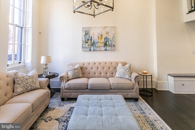 living room featuring an inviting chandelier and dark hardwood / wood-style floors