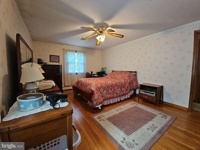 bedroom with ceiling fan, ornamental molding, a baseboard radiator, and hardwood / wood-style floors