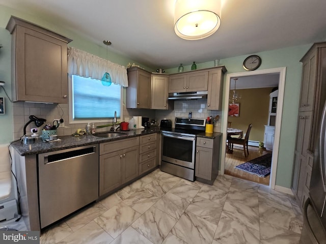 kitchen with backsplash, pendant lighting, stainless steel appliances, dark stone counters, and sink