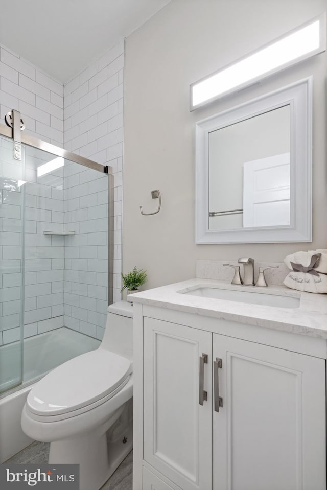 full bathroom with vanity, toilet, and bath / shower combo with glass door