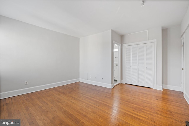 unfurnished bedroom featuring light wood-type flooring and a closet