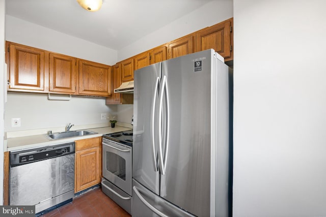 kitchen with dark tile patterned flooring, appliances with stainless steel finishes, sink, and range hood