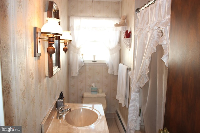 bathroom with sink, a baseboard radiator, and plenty of natural light