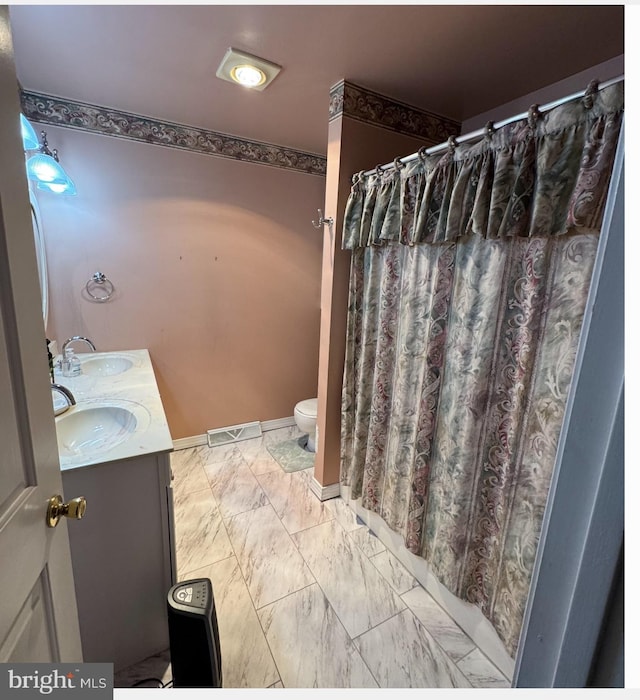 bathroom featuring vanity, toilet, and walk in shower