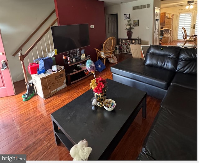 living room featuring wood-type flooring and ceiling fan