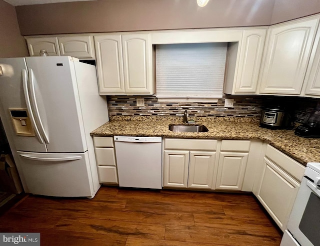 kitchen with sink, dark stone countertops, white cabinetry, and white appliances