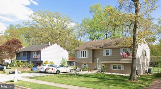 raised ranch featuring central AC unit and a front lawn