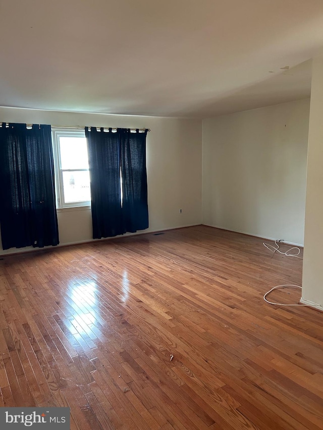 unfurnished room with hardwood / wood-style flooring