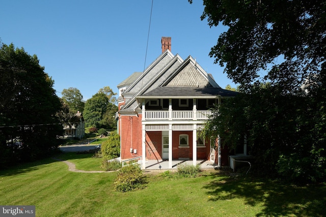 130 E Linn St, Bellefonte, PA 16823 - back of property with a lawn, a patio area, brick siding, a chimney, and a balcony