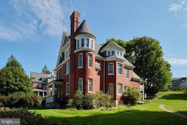 exterior space featuring a front lawn and a wall mounted AC