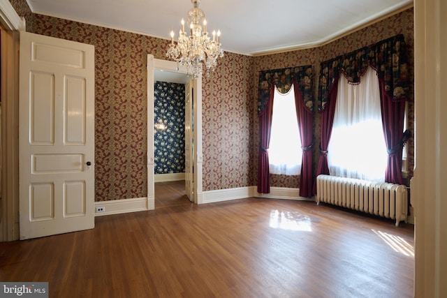 130 E Linn St, Bellefonte, PA 16823 - empty room featuring an inviting chandelier, wallpapered walls, radiator, and wood finished floors