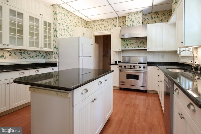 kitchen with white cabinets, stainless steel appliances, a drop ceiling, and sink