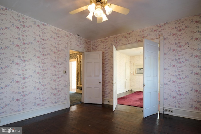 spare room featuring ceiling fan, dark hardwood / wood-style floors, and a wall unit AC