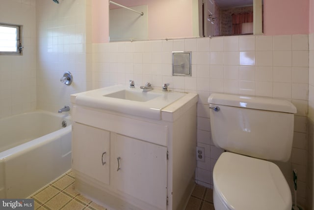 full bathroom with tile walls, vanity, toilet, and bathing tub / shower combination