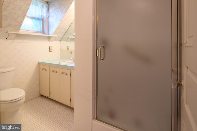 bathroom featuring a skylight, vanity, toilet, an enclosed shower, and tile patterned flooring