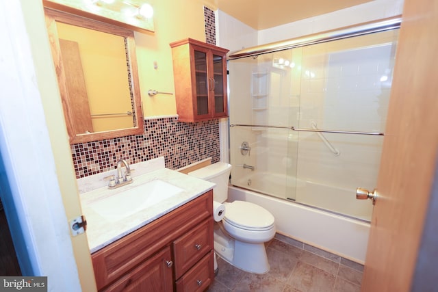 full bathroom with tile walls, backsplash, shower / bath combination with glass door, vanity, and toilet