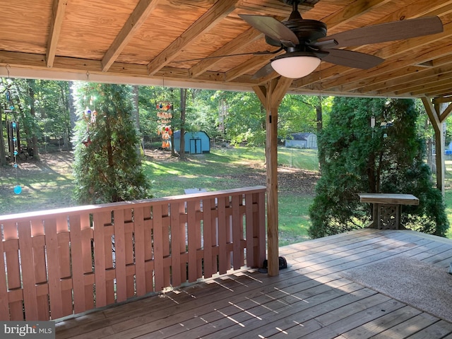 wooden terrace featuring a shed and ceiling fan