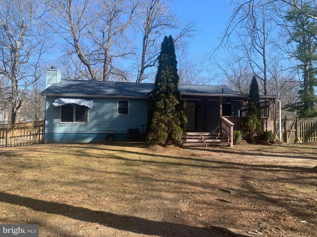 rear view of house with a lawn and covered porch