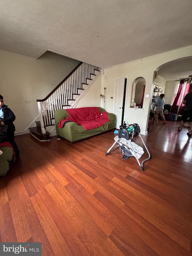 living room with a textured ceiling, wood-type flooring, and ceiling fan