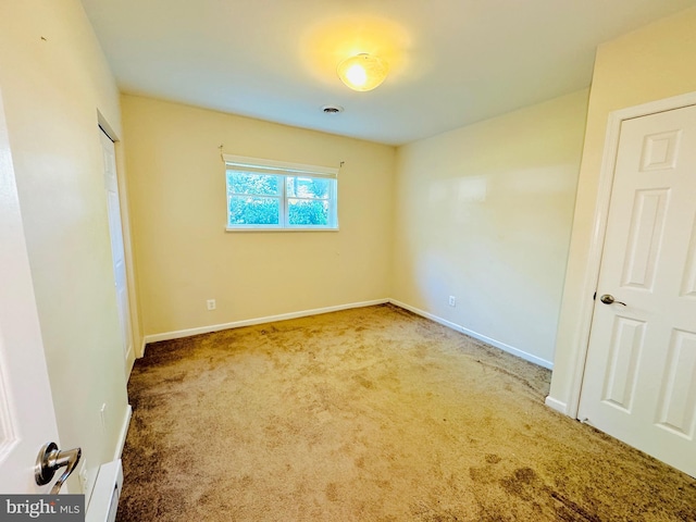 unfurnished bedroom with visible vents, baseboards, carpet, and a baseboard radiator
