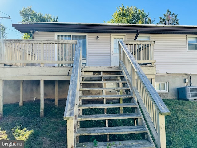 exterior space with central air condition unit, a wooden deck, and stairway