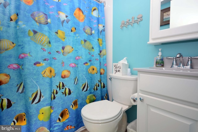 bathroom with curtained shower, vanity, and toilet